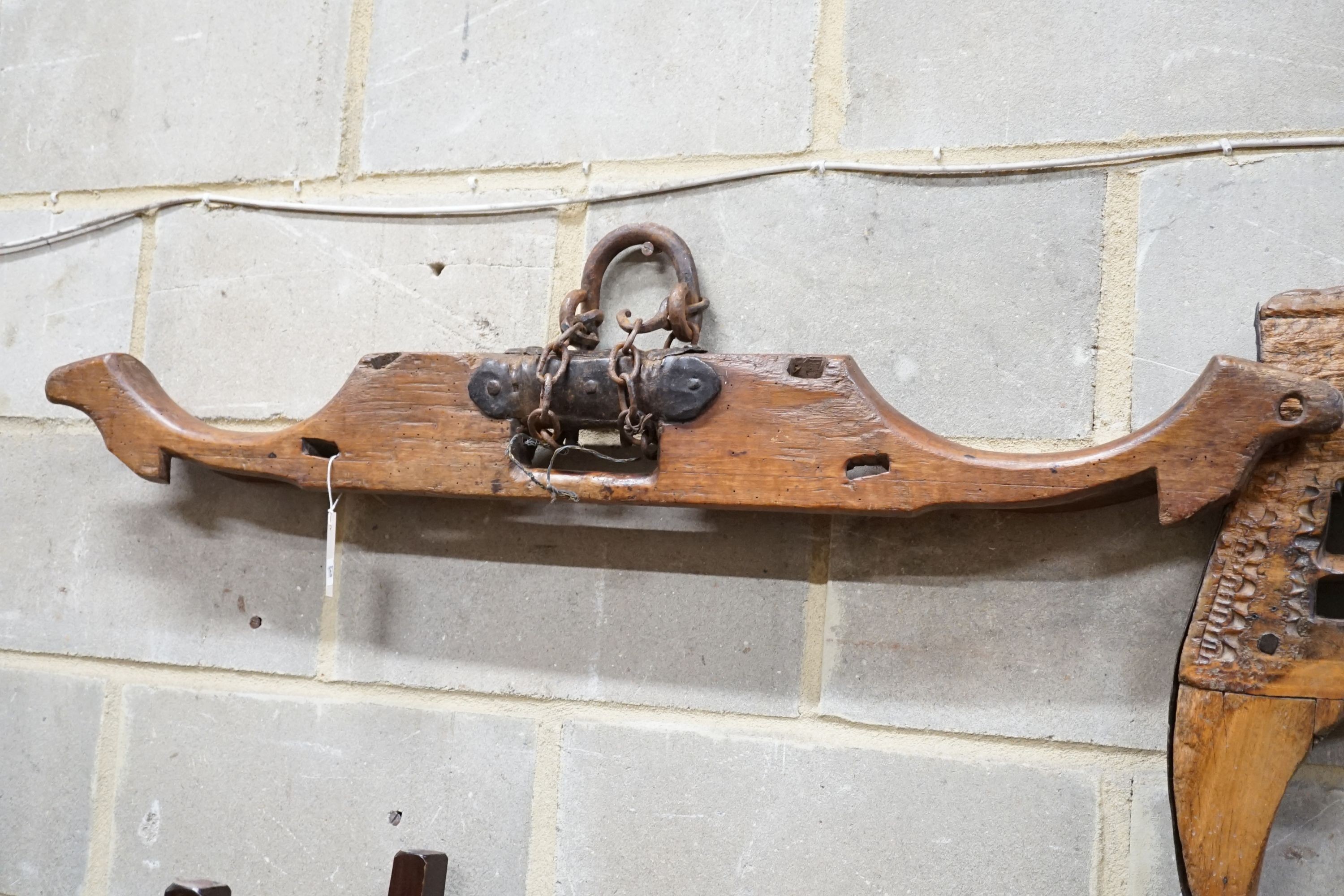 A carved hardwood ox yoke with plaque inscribed Antonio Gonzalez Vila Verde, width 110cm and another plainter yoke, width 111cm